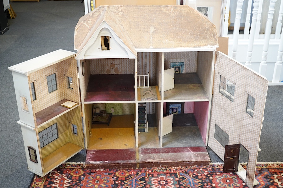 A large early 20th century J G Lines doll’s house, of plywood and tinplate construction, with two front opening sections and four internal rooms, 92cm high, 80cm wide, 60cm deep. Condition - fair